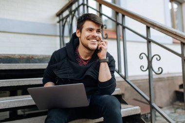 Şehir merkezinde dizüstü bilgisayarıyla çalışan genç bir erkek. Belgesinde bir şey yazan bağımsız bir kişi. İnternet üzerinden arkadaşlarla sohbet etmek, webcam. Telefonda konuşuyorlar.
