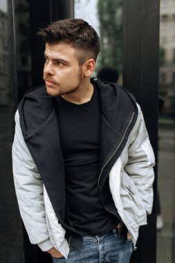 Şehirde dolaşan genç bir adamın portresi. Esmer, sakallı. Neşeli, güzel gülümseme.