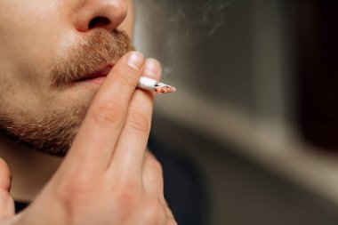 Adam sigara içiyor. Sigara dumanının yayılması. Bıyık
