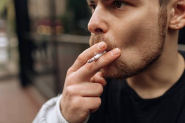 Adam sigara içiyor. Sigara dumanının yayılması. Bıyık