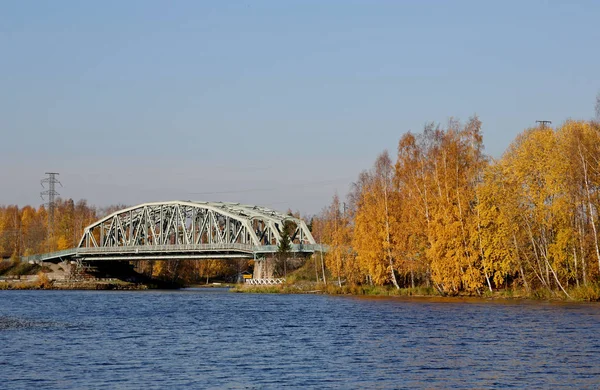 Stalowy most kolejowy nad jeziorem w słoneczny jesienny dzień. — Zdjęcie stockowe