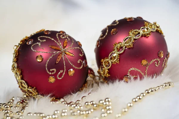 Ett par lila glänsande julbollar med guldpärlor Royaltyfria Stockfoton
