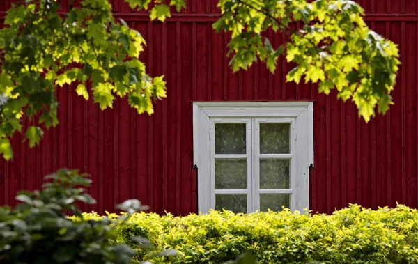 A red cottage with white window.