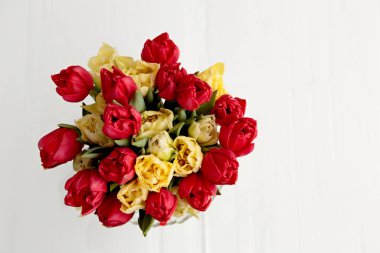 Yukarıdan çekilen vazodaki beyaz ve kırmızı laleler.