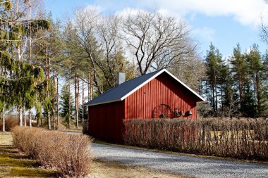 Kırsal bölgedeki kır yolunun yanındaki eski kırmızı boyalı sauna binası.