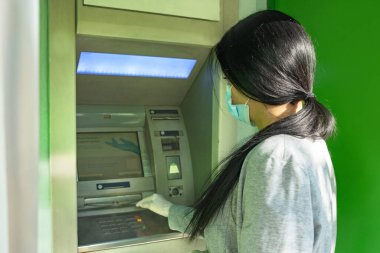 Kız eldiven olarak para makinesi kullanıyor.