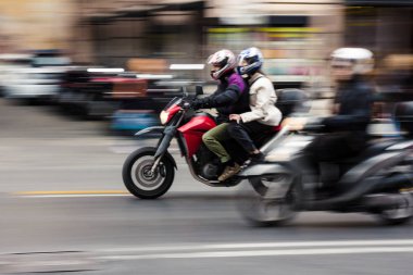 Bir çift bir motosiklet üzerinde yakınlaştırma trafik Roma, İtalya. 19 Şubat 2017.
