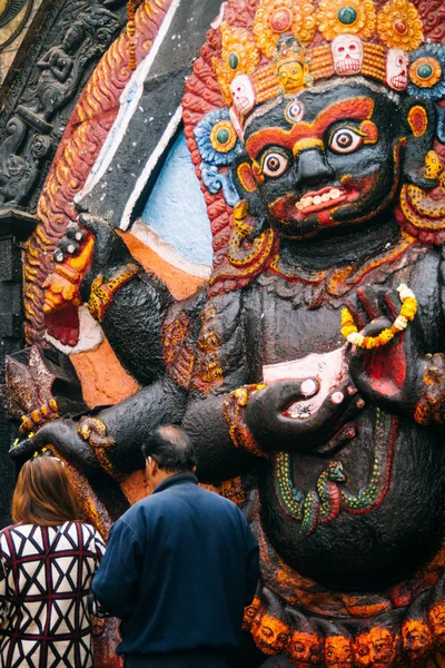 Un par de lugares ofrendas al pie de una gran estatua del dios hindú Bhairav. Plaza Durbar, Katmandú, Nepal. 22 marzo 2017 —  Fotos de Stock