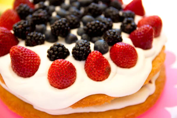 Light sponge cake with white icing and mixed berries (strawberri — Stock Photo, Image