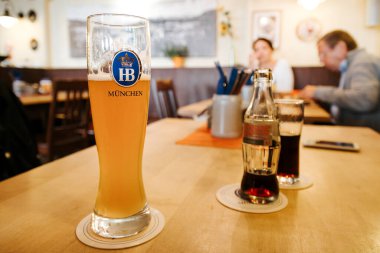 Bad Tolz, Almanya - 19 Eylül 2015: Bad Tlz, Bavyera 'da bir restoranın içindeki ahşap bir masada büyük Hofbrau birası.
