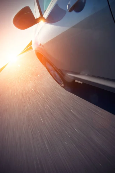 Otomobil hızlı hızlı güneş doğarken taşır. — Stok fotoğraf