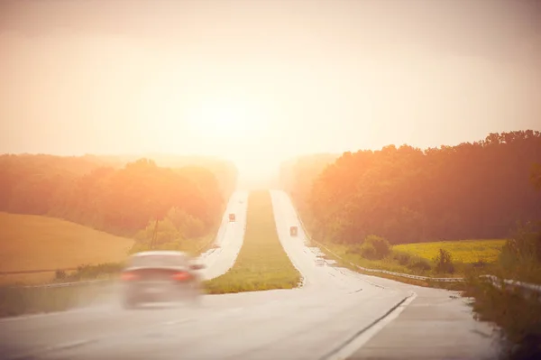 Auto bei Sonnenaufgang mit hoher Geschwindigkeit auf der Autobahn — Stockfoto