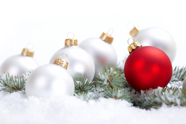 Рождественские красивые белые и красные шары с огненной ветвью и снегом на белом фоне
