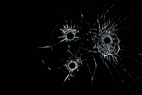 ガラスの 3 つの銃弾の穴が黒い背景にクローズ アップ — ストック写真