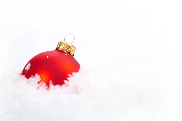 Vánoční krásný červený míček se sněhem na bílém pozadí — Stock fotografie