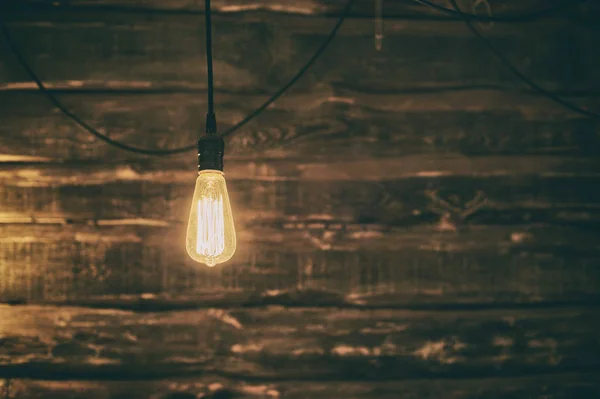 在黑暗的木制背景的爱迪生灯泡 — 图库照片