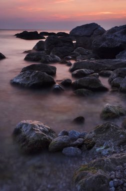 Renkli yaz deniz manzarası. gün batımında kayalık sahil