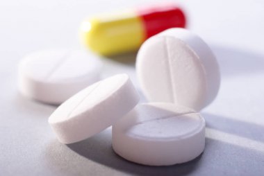 beyaz zemin üzerine sarı kırmızı kapsül ile beyaz uyuşturucu