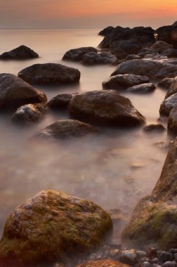 Renkli yaz deniz manzarası. gün batımında kayalık sahil