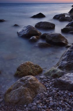 Renkli yaz deniz manzarası. gün batımında kayalık sahil