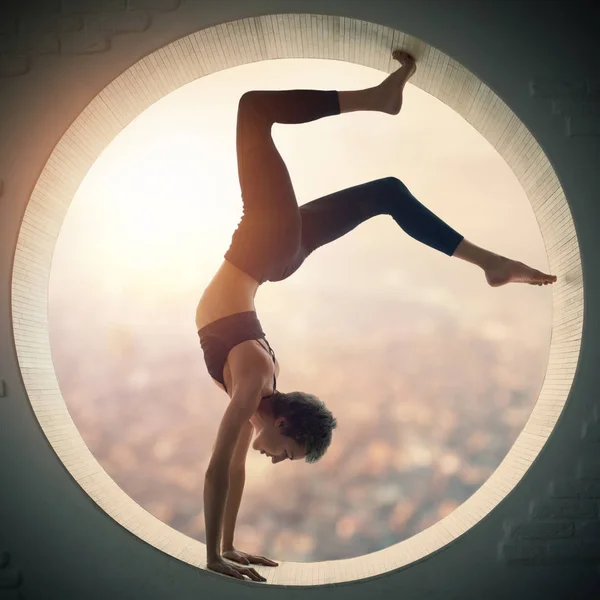 Mooie sportieve fit yogi vrouw praktijken yoga handstand asana Bhuja Vrischikasana - Scorpion handstand pose in een venster — Stockfoto