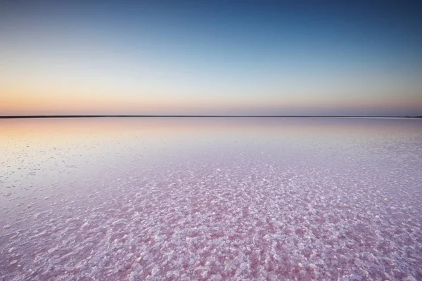 Sůl a nálevu z růžového jezera, barevné mikrořas Dunaliella salina při západu slunce — Stock fotografie