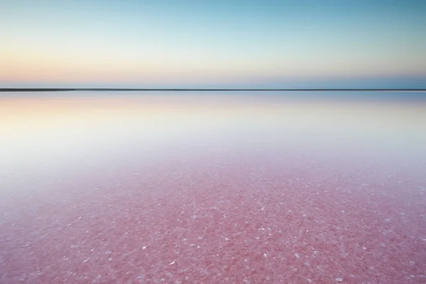 Sal e salmoura de um lago rosa, colorido por microalgas Dunaliella salina ao pôr do sol — Fotografia de Stock