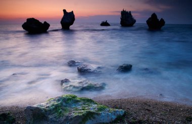 Renkli yaz deniz manzarası. gün batımında kayalık sahil