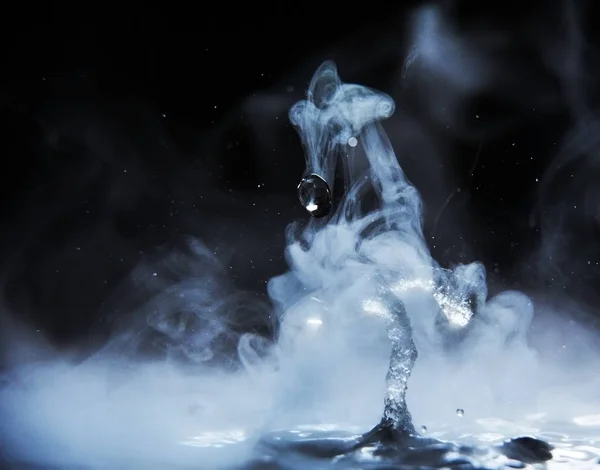 Boiling water splash with steam on black background closeup — Stock Photo, Image