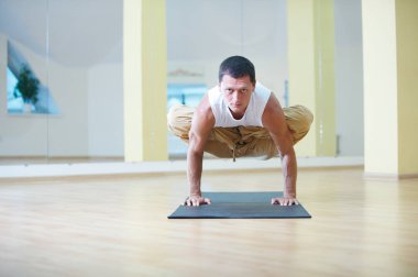 Yoga egzersizleri - yapan bir güçlü genç erkek Padma Bakasana Lotus vinç poz yoga Studio