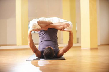 Yoga egzersizleri - yapan bir güçlü genç erkek Urdhva Padmasana inversiyon lotus poz yoga stüdyosu
