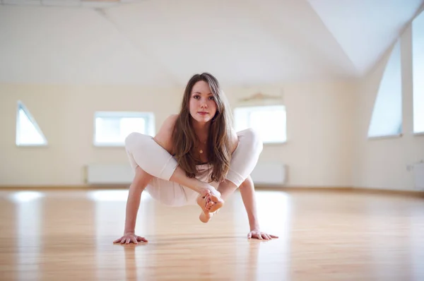 Красивая женщина практикует handstand yoga asana Bhuja Pidasana - Поза давления руки в студии yoga — стоковое фото