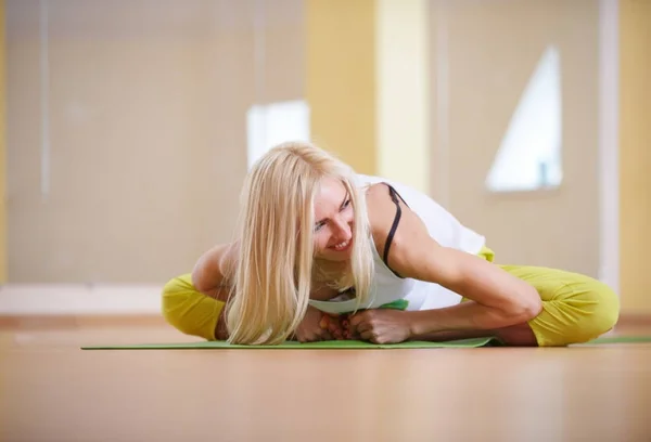 Smuk sporty fit yogi kvinde praktiserer yoga asana Adho Mukha Baddha Konasana - sommerfugl udgør i fitnessrummet - Stock-foto