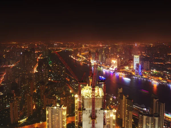 Gebouwen in aanbouw met kranen en verlichting 's nachts, Shanghai, China — Stockfoto