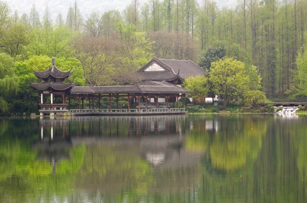 Puente tradicional chino con pabellón en la costa de West Lake, parque público en la ciudad de Hangzhou, China —  Fotos de Stock