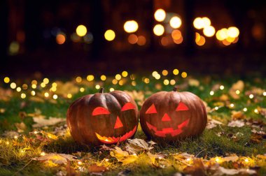 İki Halloween Pumpkins ışıklar içinde A Park gece bir çim üzerinde gülümseyen