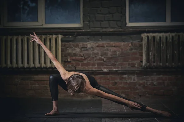 Krásná sportovní fit yogini žena praktiky jógových ásán v temné chodbě — Stock fotografie