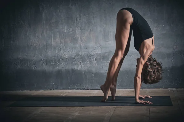 Güzel sportif yogini kadın uygulamaları yoga asana karanlık koridorda uygun — Stok fotoğraf
