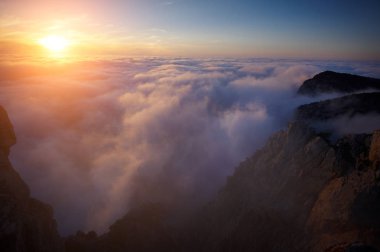 Gün batımında sisli sis dağlarının görünümü