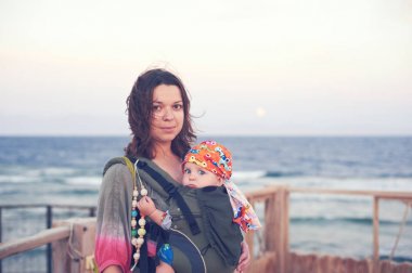 Genç bir anne ile bebeği bir askı içinde kumsalda değil