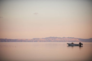 Dağlar, tekne ve sakin deniz güzel manzara