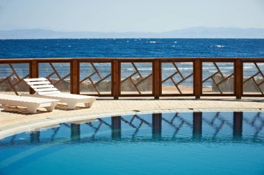 Suya yansıyan resort Havuzu Çit. Arka planda saf mavi gökyüzü.