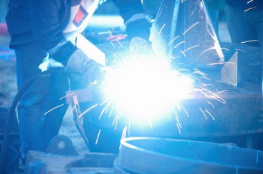 Endüstriyel elektrot Kaynakçı ile yüz kalkan ve genel olarak atölye bir çelik boru kaynak mavi.