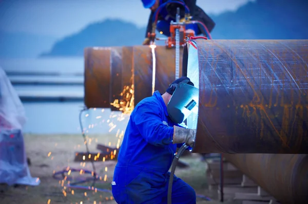 带面罩和蓝色整体焊接的工业电极焊机车间钢管. — 图库照片