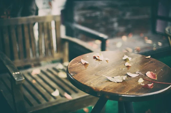 Ξύλινο τραπέζι μπροστά από το αφηρημένο θολή φόντο του έξω πόρτα καφέ — Φωτογραφία Αρχείου