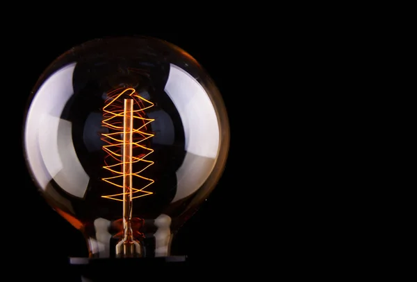 Classic Edison light bulb on black background — Stock Photo, Image