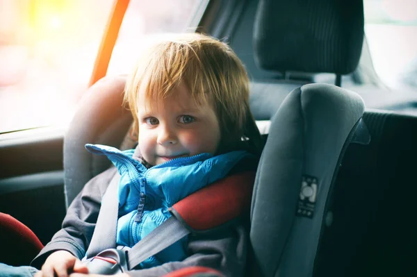 Araba koltuğuna oturan güzel yürümeye başlayan çocuk portresi. Çocuk ulaşım güvenliği — Stok fotoğraf