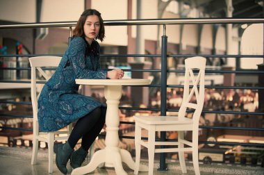 kafede oturan genç bir rüya gibi kadın portresi