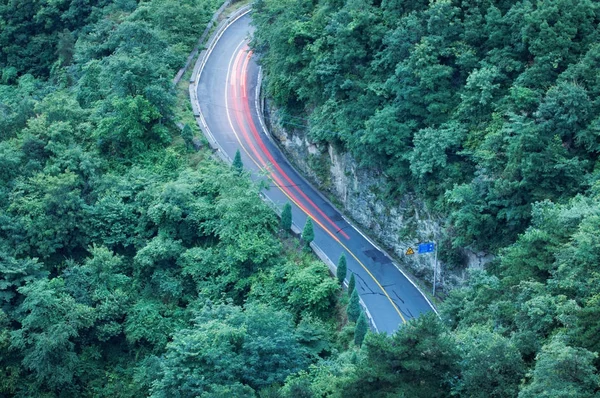 Kurvenreiche Straße durch den Wald. Luftbild. — Stockfoto