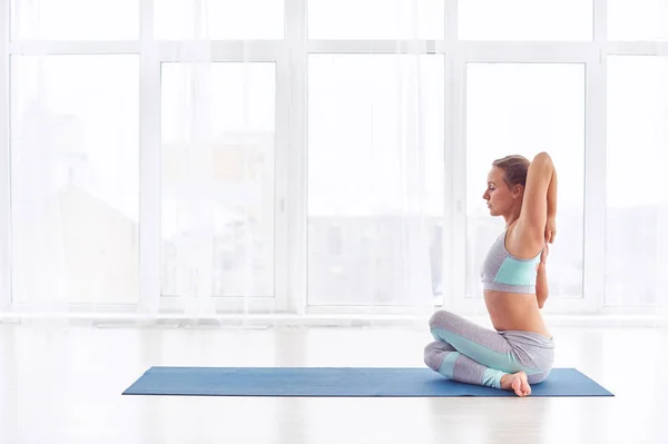 Schöne junge Frau übt Yoga Asana Garudasana - Adler-Pose im Yoga-Studio — Stockfoto